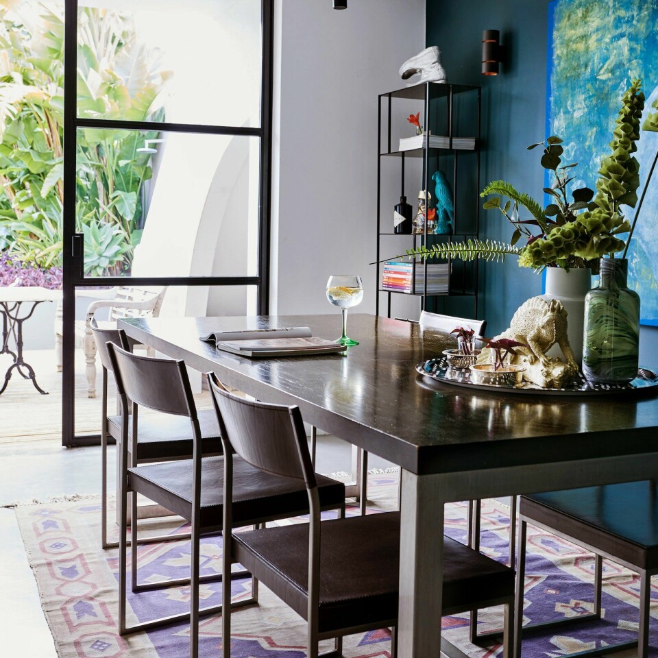De azuurblauwe muur in de eetkamer verbindt de binnen- met de buitenruimte. Het tapijt is een berber.
