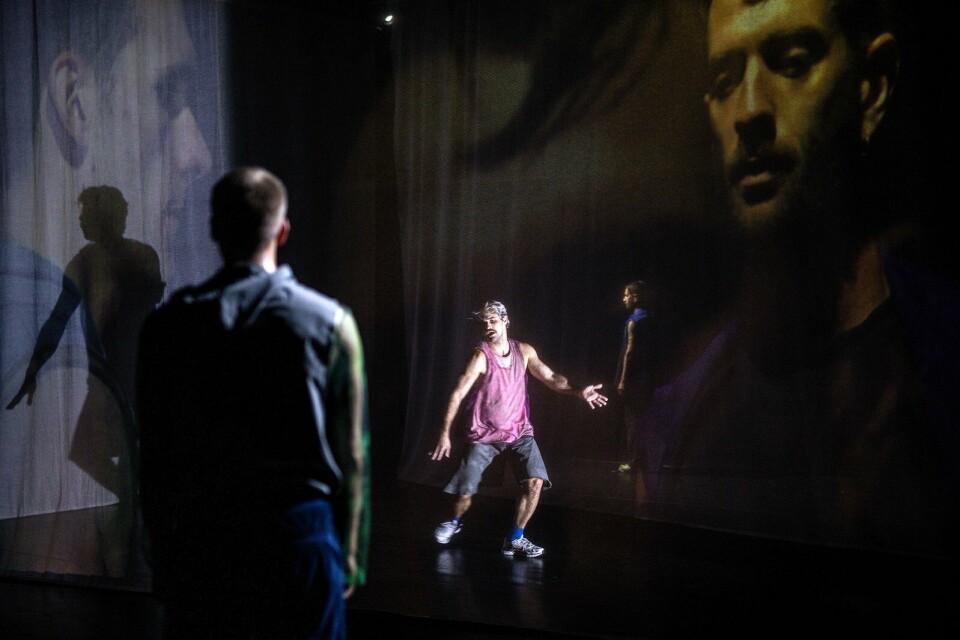 scènefoto uit The End - Part 2 met een van de dansers in roze shirt en op achtergrond videobeelden