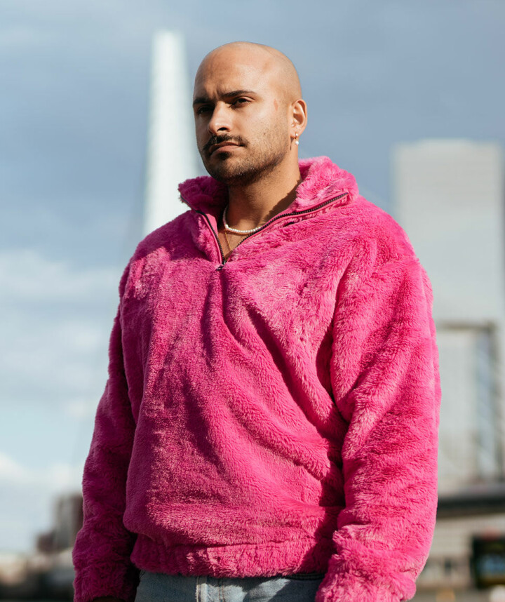 “Het eendimensionale beeld van het witte lhbtiqa+ slachtoffer en de dader van kleur doet niemand recht” Rocher Koendjbiharie in roze trui voor de Erasmusbrug
