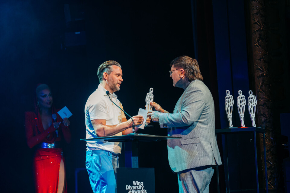 Acteur en auteur Kevin Hassing (links) reikt de Winq Community Award 2024 uit aan Thomas Philip Acid van boekhandel De Queer Boekenkast.