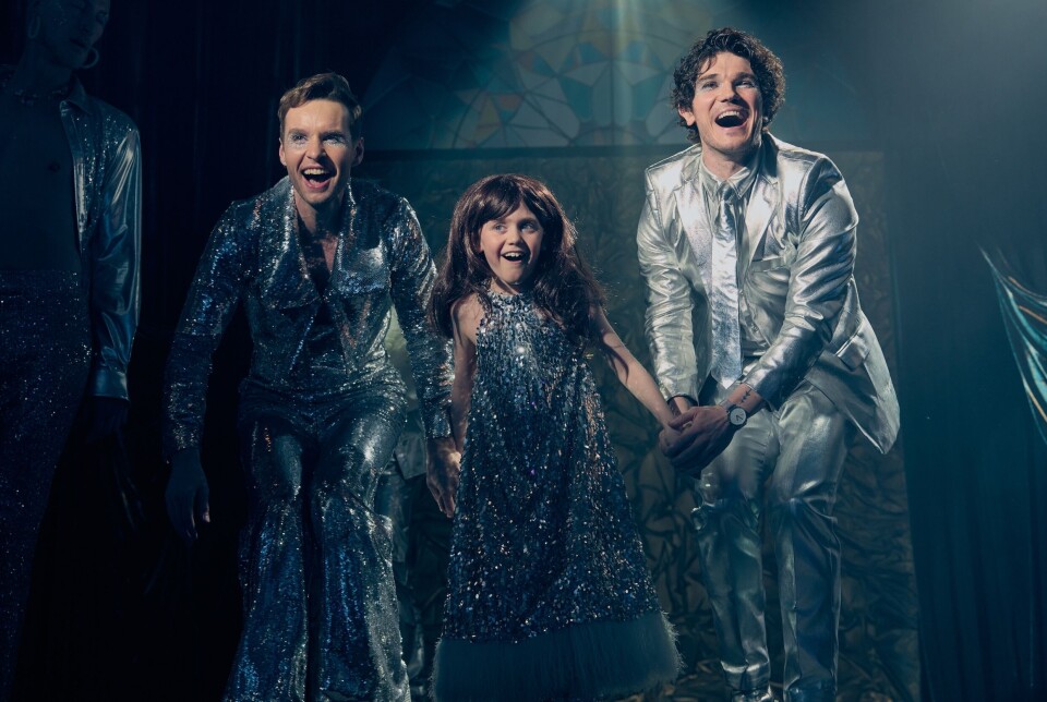 Fantasie/openingsscéne waarin v.l.n.r. Gabe (Sion Daniel Young), Jake (Leo Harris) en Andy (Fra Fee) het nummer ‘It’s getting better’ van Cass Elliot ten gehore brengen. Twee mannen met een kind