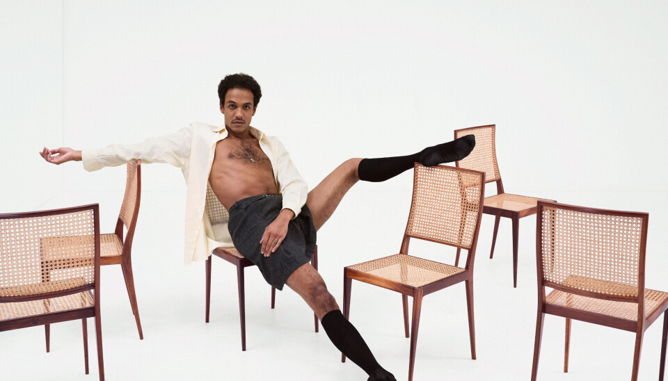 Overhemd:
via Tommy Page / rok: via Marbles Vintage / sokken: Falke Jesse Mensah halfnaakt op een stoel