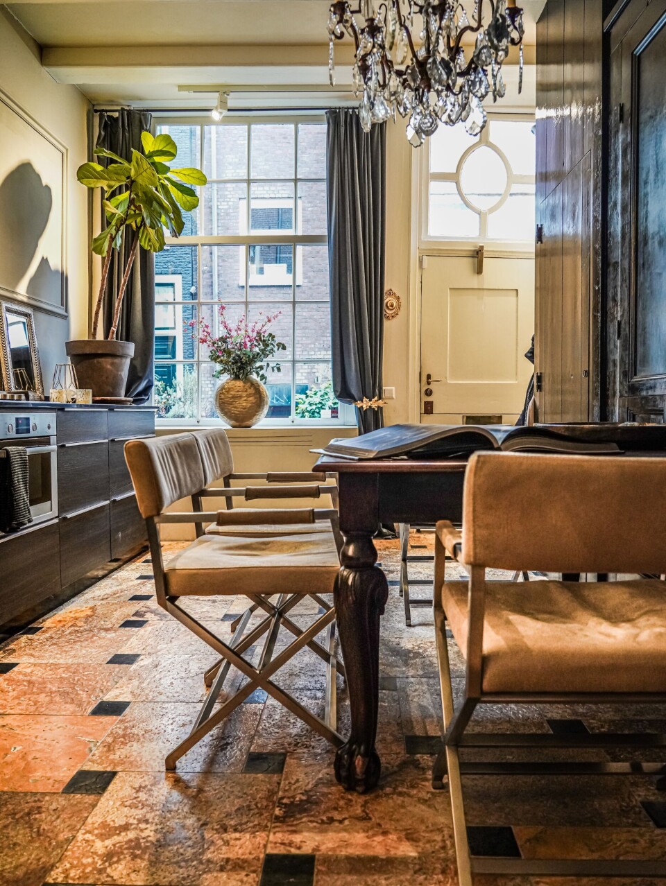 In de keuken een oude tafel uit de familie met de enorme kroonluchter van Eichholtz erboven. In de keuken een oude tafel uit de familie met de enorme kroonluchter van Eichholtz erboven.