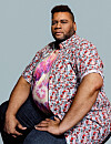Zittend portret van Emil Angelo Locadia in fel patroonhemd en tie-dye T-shirt