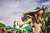Persoon zwaait met regenboogvlag bij een straatfeest in Olinda, Brazilië.