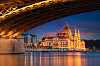 Verlicht Hongaars parlementsgebouw aan de Donau in Boedapest, met kleurrijke weerspiegelingen in het water.