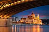 Verlicht Hongaars parlementsgebouw aan de Donau in Boedapest, met kleurrijke weerspiegelingen in het water.