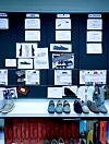 Winkelwand met wandelschoenen, productkaarten en schoenendozen.