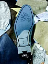 Blauwe New Balance-schoenzool tussen kleurrijke stoffen en textielpatronen.